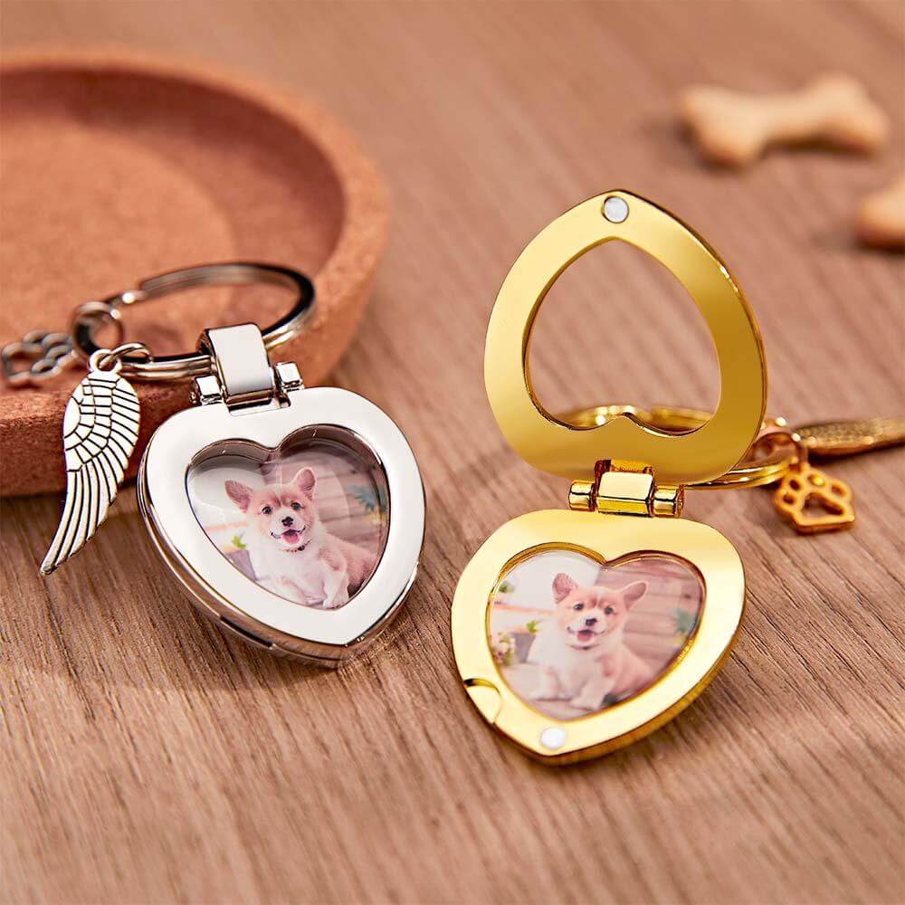Open view of gold and silver pet photo keychains on wooden table